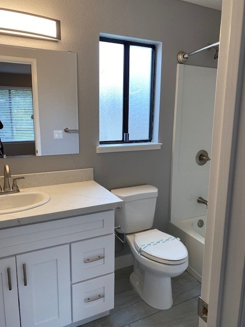 A white toilet with a blue towel in a bathroom.